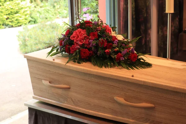 Um caixão com um arranjo de flores em uma morgue — Fotografia de Stock