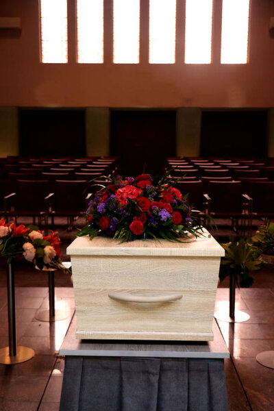 A coffin with a flower arrangement in a morgue