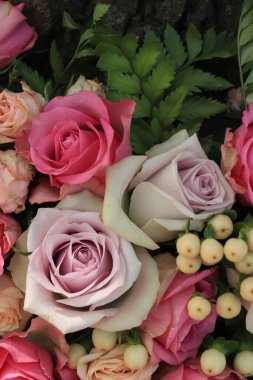 Büyük bir düğün süsü içinde pembe ve mor güller.