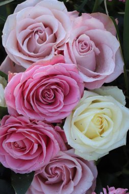 Çiçeklerle süslenmiş pembe, mor ve beyaz düğün gülleri.