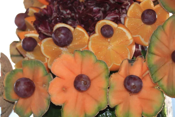 在游轮自助餐上展出的瓜果 橙子和葡萄制成的花 — 图库照片