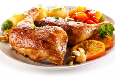 Grilled chicken legs with vegetables on white background  clipart