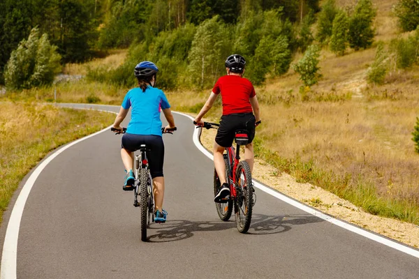 田舎で自転車に乗って若いカップルの背面図 — ストック写真