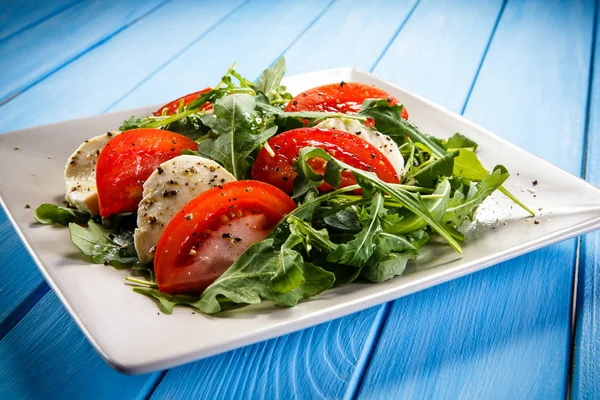 Salată Caprese Mozzarella Roșii Arugula Placă Albă Fundal Albastru Din — Fotografie, imagine de stoc