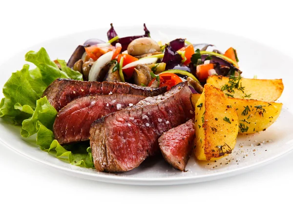 珍しい牛肉ステーキ ロースト ポテトと白皿の上の野菜のサラダ — ストック写真