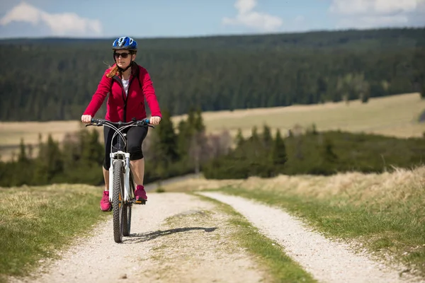 フィールドでヘルメット乗って自転車を保護する上で魅力的な女性 — ストック写真