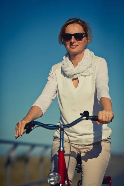 自転車でカジュアルな服装できれいな女性 スポーツや活動のコンセプト — ストック写真