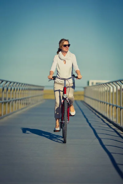 穿着便服的漂亮女人骑自行车 体育和活动概念 — 图库照片