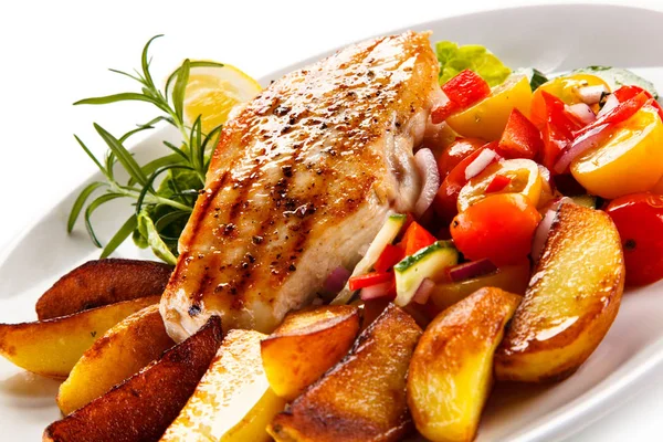 Detail view of grilled chicken fillet with baked potatoes and fresh salad on plate isolated on white background