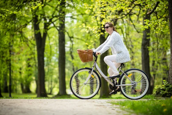 公園で女性の自転車に乗って白いカジュアルでアクティブな女性 — ストック写真