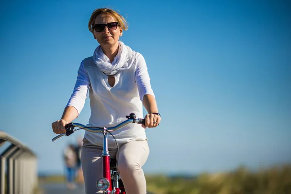 穿着便装的漂亮女人骑着红色的自行车 体育和休闲概念 — 图库照片