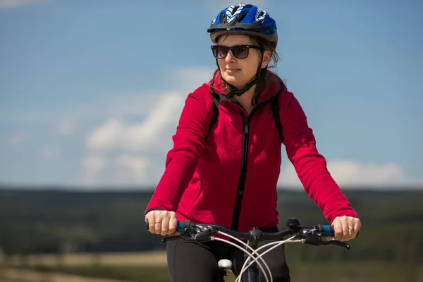 フィールドで自転車に乗ってスポーツ ウエアでアクティブな大人の女性 スポーツや活動のコンセプト — ストック写真