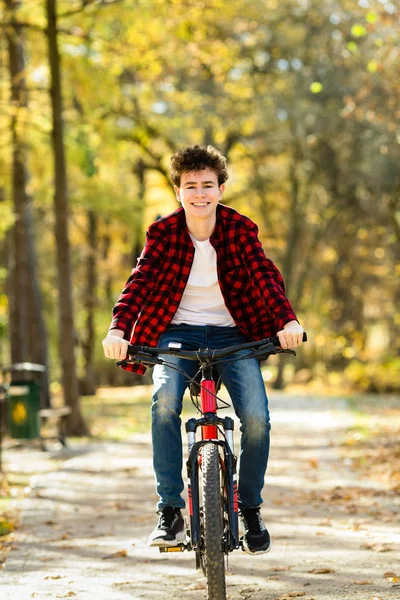 青少年男孩骑自行车在城市公园 — 图库照片