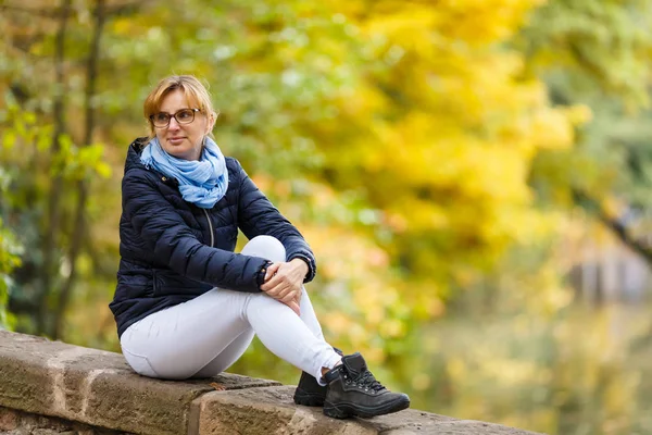 Erwachsene Frau Sitzt Auf Steinzaun Herbstlichen Park — Stockfoto
