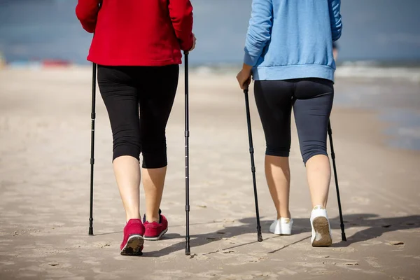 低剖面的妇女走在一起与旅游棍子在海边 北欧步行 — 图库照片