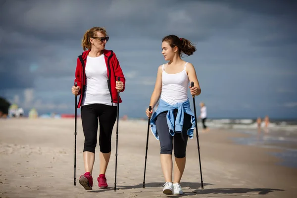 在海边散步的妇女的前视图 北欧步行 — 图库照片