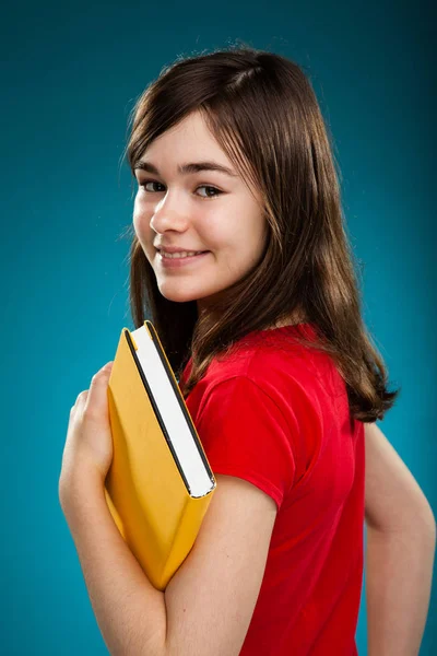 Menina Bonita Adolescente Segurando Livro Amarelo Fundo Azul Gradiente — Fotografia de Stock