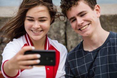 Young woman and man taking selfie photos clipart