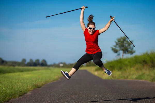 Jovem Mulher Sportswear Pulando Divertindo Com Paus Turísticos — Fotografia de Stock