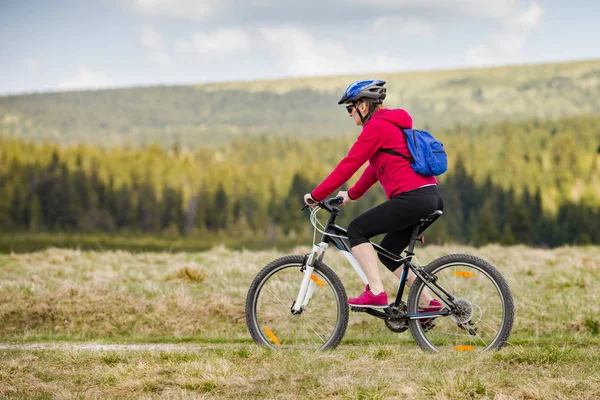 フィールドで自転車に乗ってスポーツ ウエアでアクティブな女性 — ストック写真