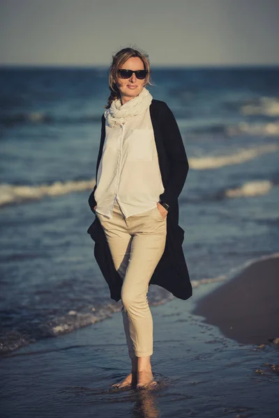 Yetişkin Kadın Güneş Gözlüğü Deniz Kenarında Yürüyüş — Stok fotoğraf