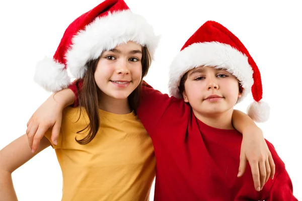 Jongen en meisje in santa's hoeden — Stockfoto