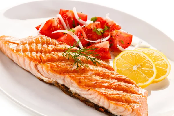 烤鲑鱼鱼片与西红柿块和切片柠檬在白盘子上的细节视图 — 图库照片