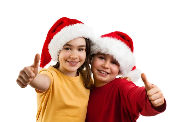 Menino e menina em chapéus de Papai Noel — Fotografia de Stock