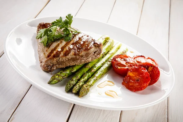 Carne Grelhada Com Espargos Tomates Prato Branco — Fotografia de Stock