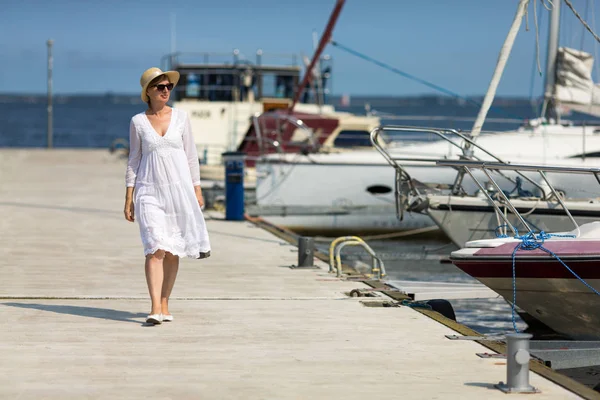 Kadın Şapka Beyaz Elbise Deniz Kenarında Yürüyüş Güneş Gözlüğü — Stok fotoğraf