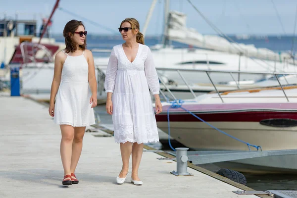 Dos Damas Vestidos Blancos Gafas Sol Caminando Orilla Del Mar — Foto de Stock