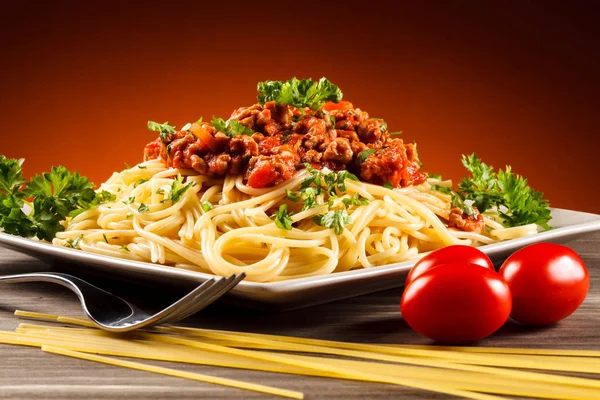 肉と木製のテーブルの上のトマトのパスタ — ストック写真
