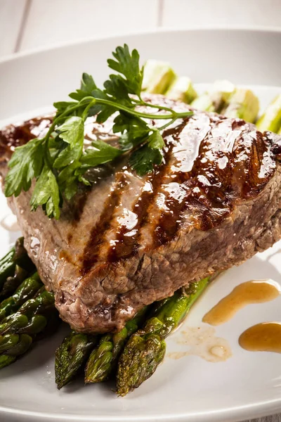 테이블에 접시에 아스파라거스와 쇠고기 스테이크 — 스톡 사진