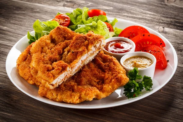 Breaded Chicken Schnitzel Fresh Vegetables Sauces White Plate Wooden Table — Stock Photo, Image
