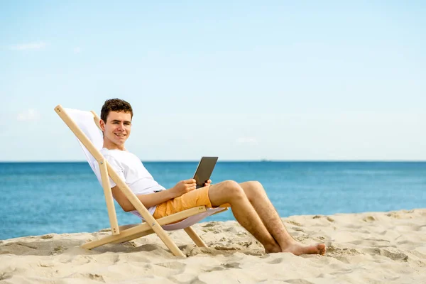 Hombre Joven Relajándose Cama Sol Playa Con Ordenador Portátil —  Fotos de Stock