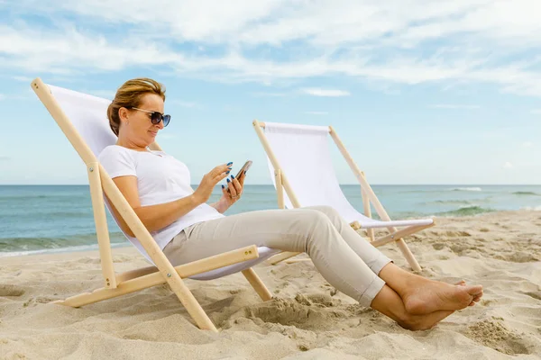 Donna Che Rilassa Sul Lettino Mare Con Smartphone — Foto Stock