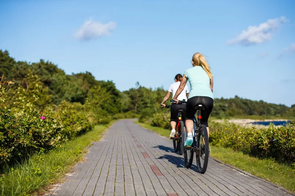 妇女在海滨骑自行车 — 图库照片