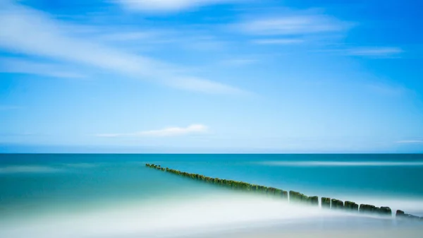 明確な砂 穏やかな水と割ることで海の景色が海の切り株 — ストック写真