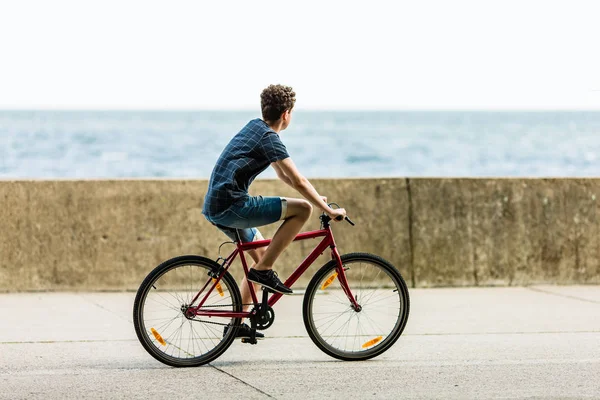 代の少年が自転車に乗って海辺 スポーツとレジャーの概念 — ストック写真