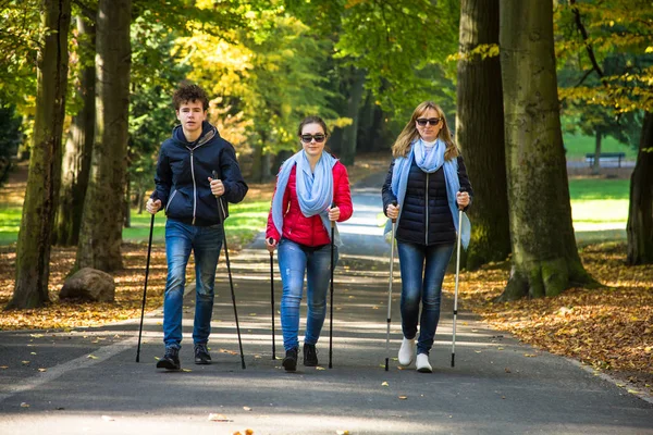 Vrolijke Familie Samen Wandelen Herfst Park Met Toeristische Stokken — Stockfoto