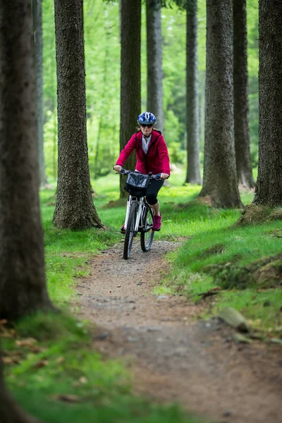 明るい春の森の中でスポーティなウェア乗馬自転車の女性 — ストック写真