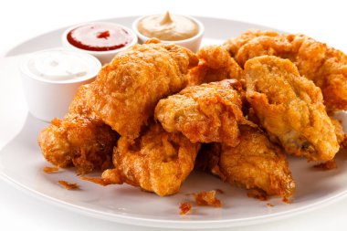 Breaded chicken wings serves with bbq sauce and mustard. clipart