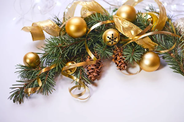 Christmas tree branch with gold balls and ribbons