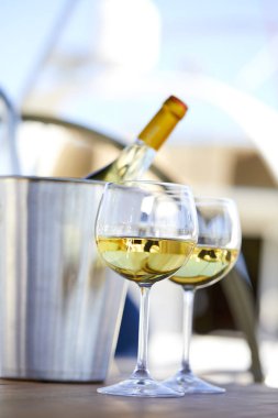 Çift kadehlerin ve kova yatında şampanya şişesi ile