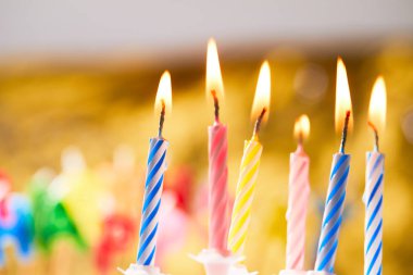 Bulanık arkaplanda renkli doğum günü mumları
