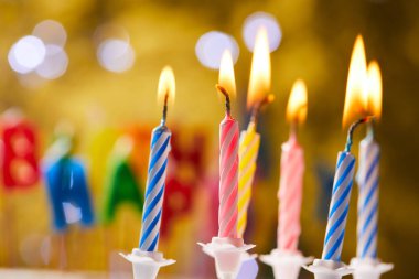 Bulanık arkaplanda renkli doğum günü mumları