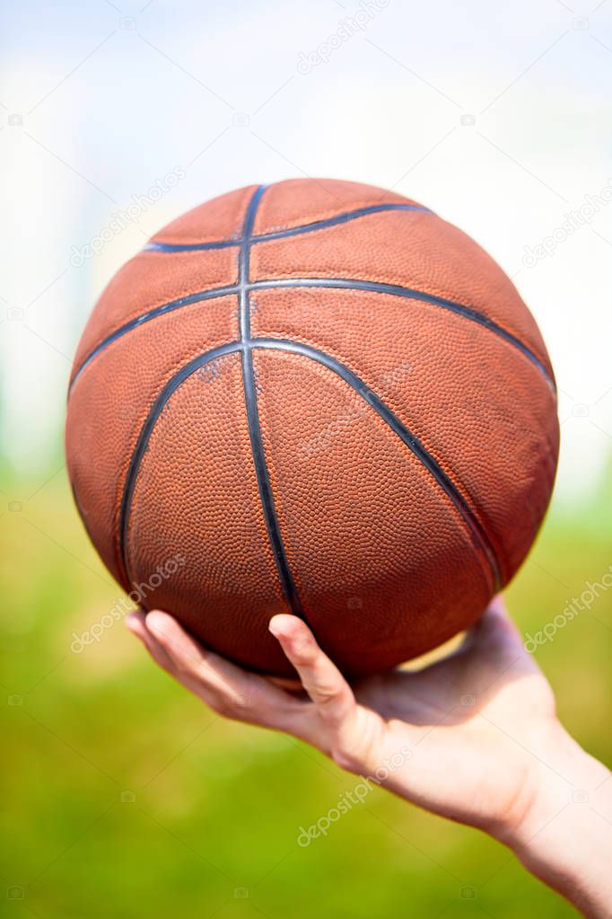 man holding basketball ball, close-up 