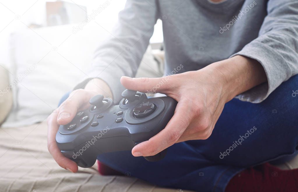 male hands holding joystick controllers while playing video games at home