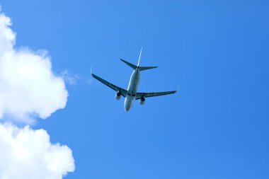 Güneşli bir günde mavi gökyüzünde uçan bir uçak.