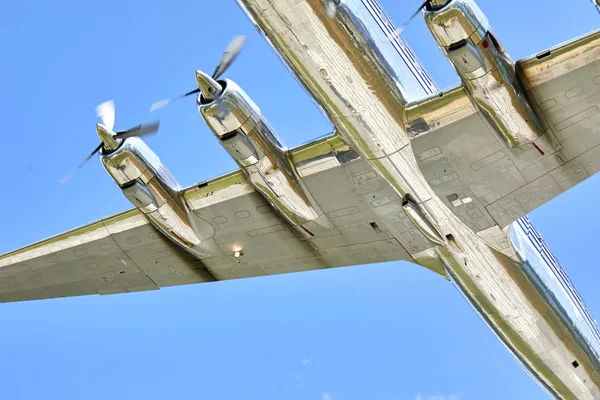 Güneşli bir günde mavi gökyüzünde uçan bir uçak.